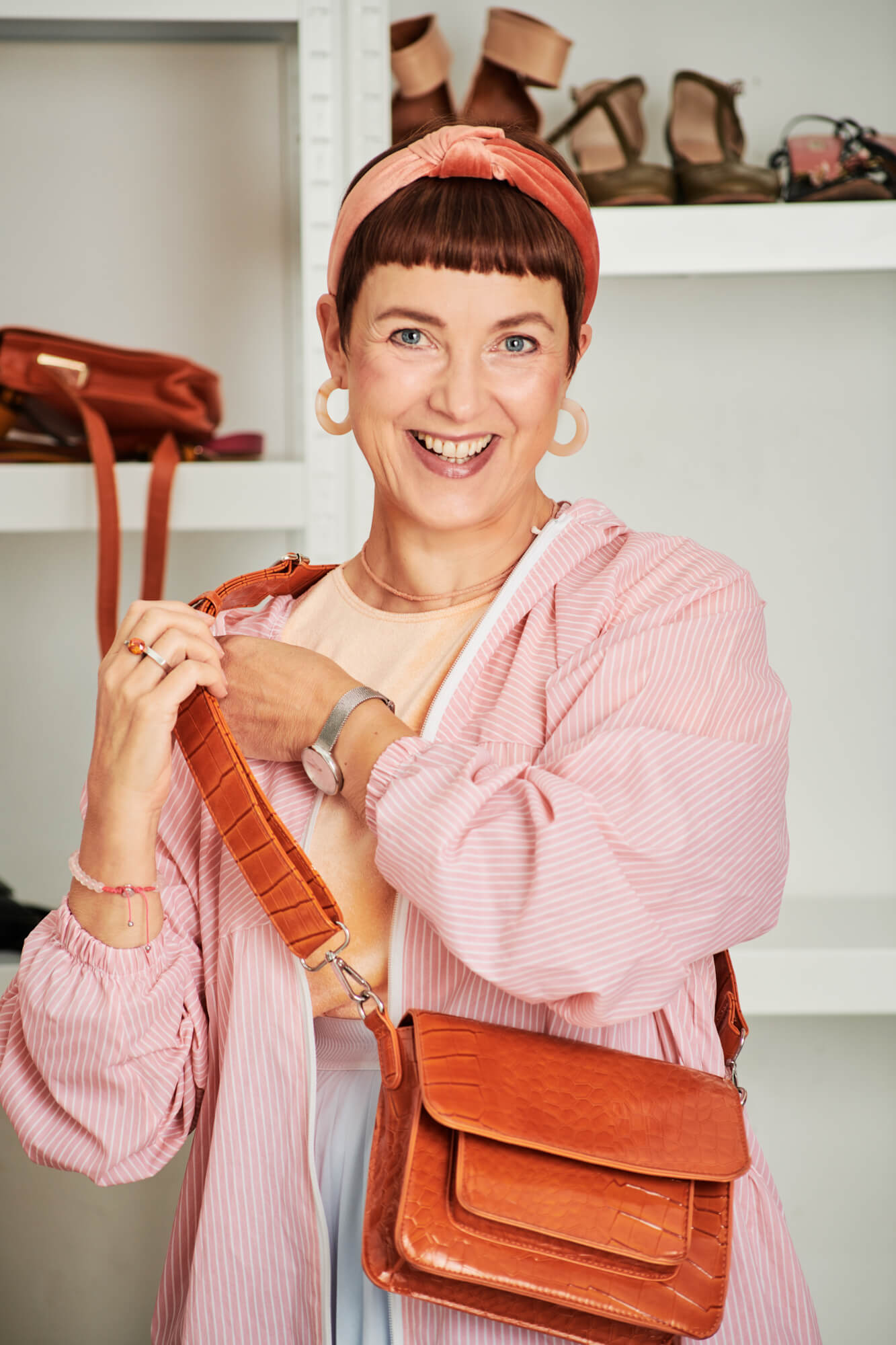 Tina in the shop with the orange bag wearing a raincoat